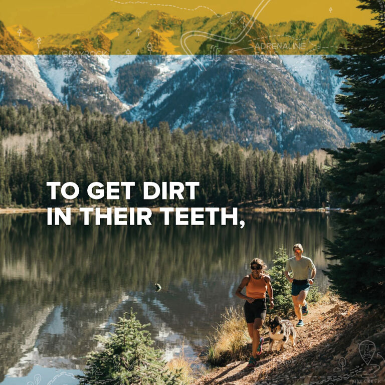 A woman and a man running through a trail wearing Teva hiking sandals